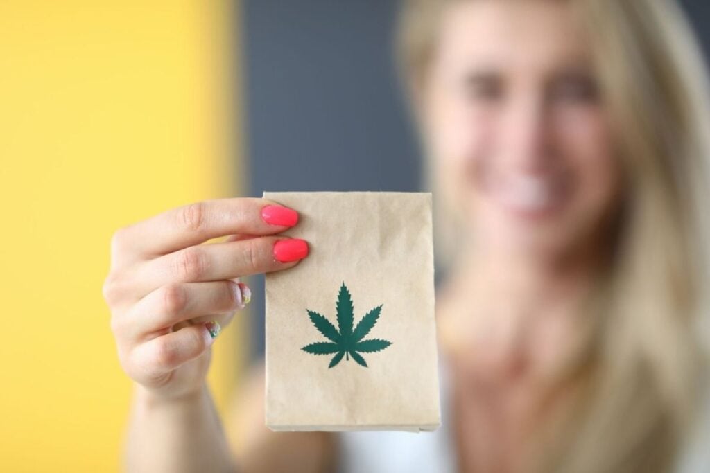 A lady holding and showing the Delta-8 product she ordered online.