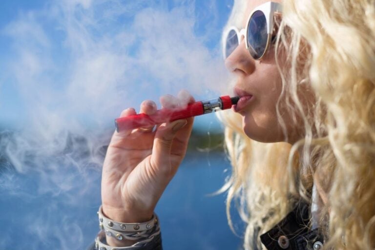 A lady vaping a cartridge after preheating it for denser smoke